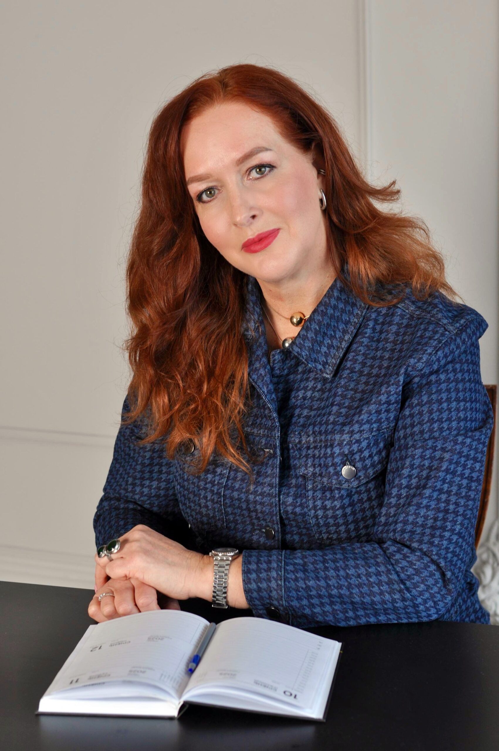 a woman sitting at a table with a book